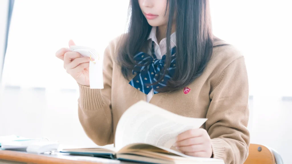 単語カードと本で勉強する学生